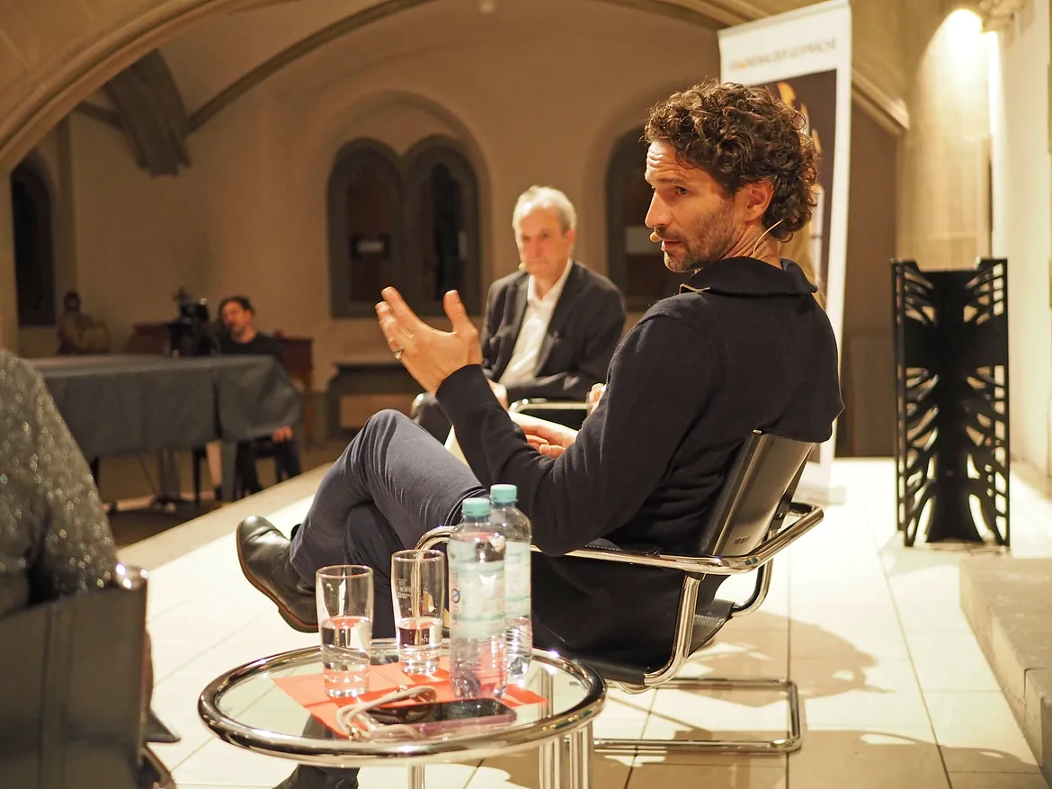 Zwei Personen auf Bühne im Gespräch.