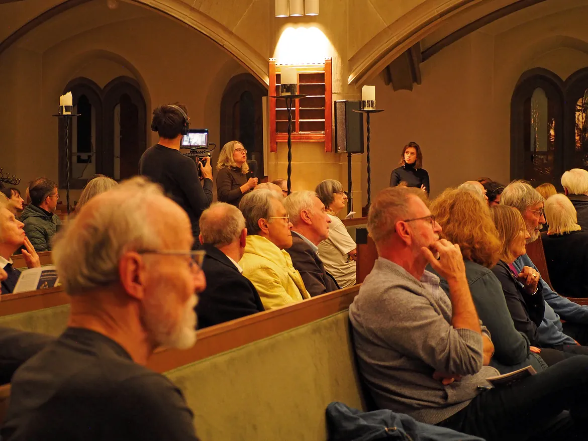 Publikum in Kirche hört zu.
